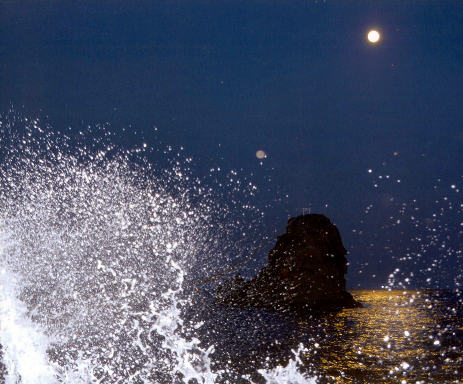 波に浮かぶ月の画像