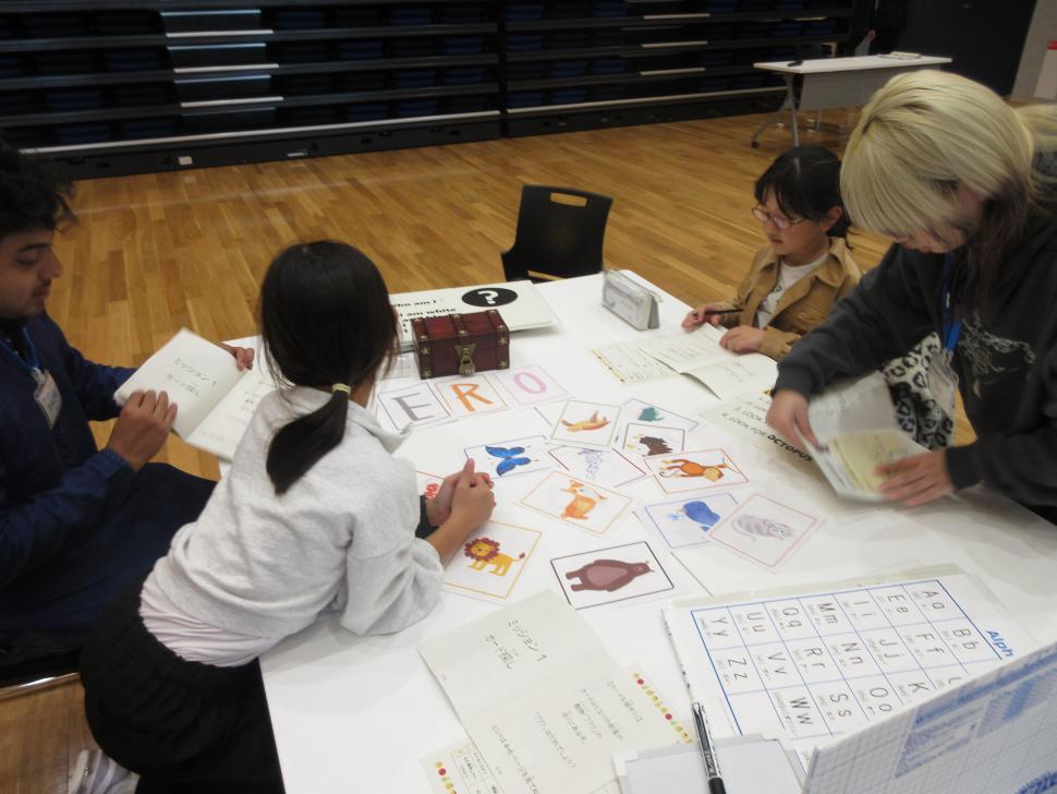 カードを使った謎解きをする小学生と留学生たち