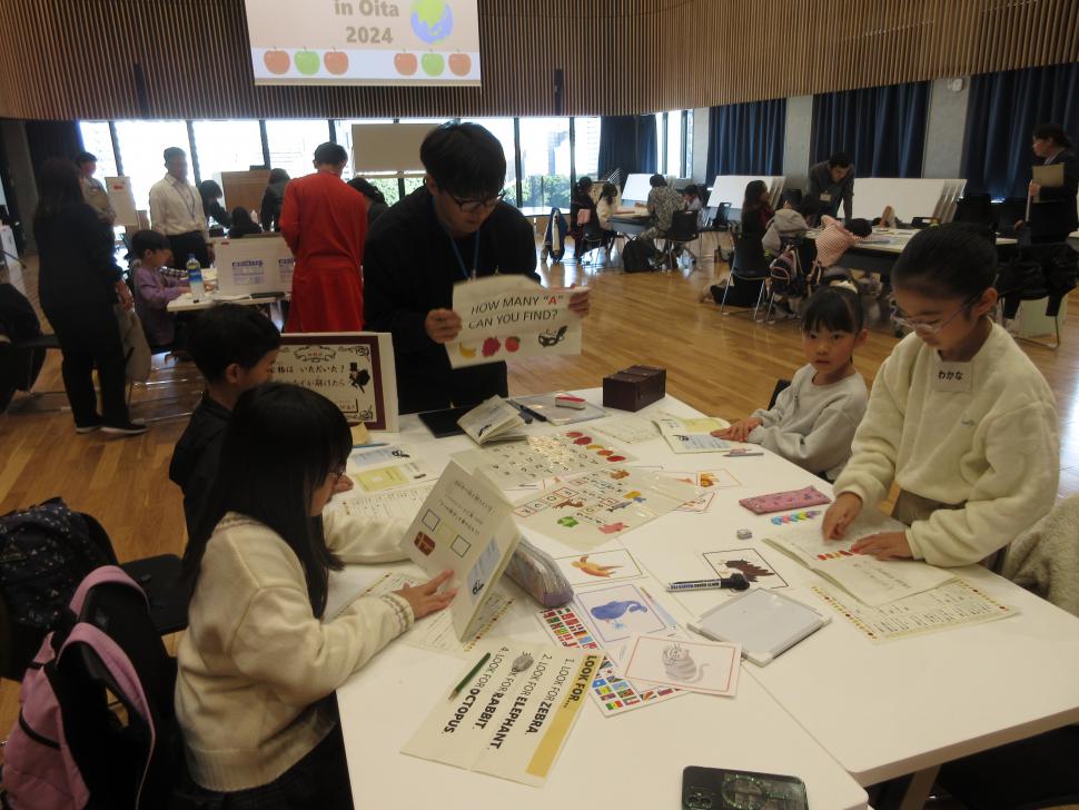 問題を見せる留学生と謎解きに挑む小学生