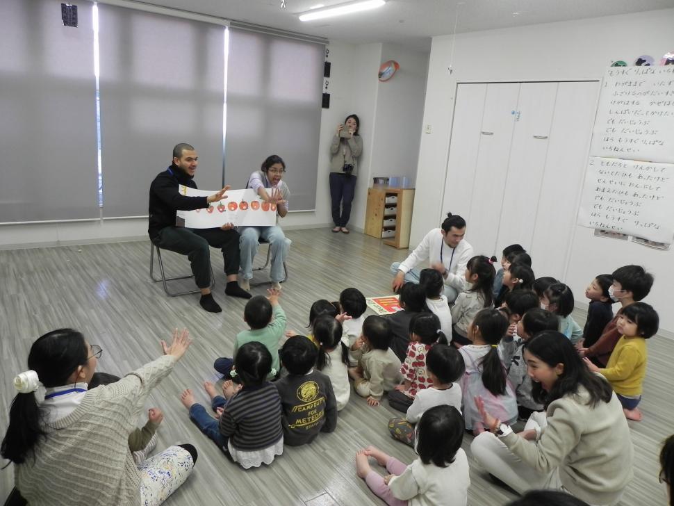 絵本の読み聞かせで交流する園児たちと留学生たち