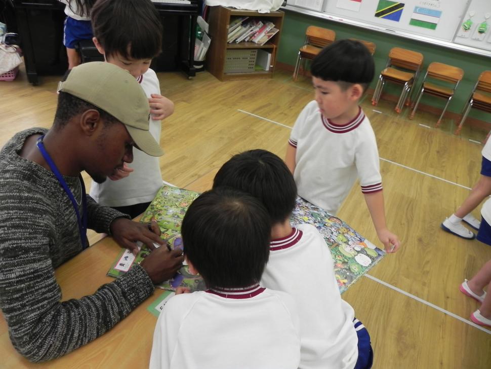 留学生と園児たちが本を見ながら交流