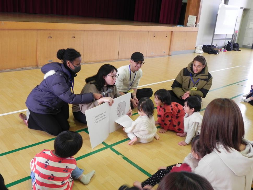 絵本の読み聞かせをする留学生と子どもたち