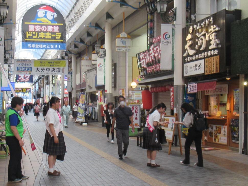 自殺予防週間街頭キャンペーン（駅前商店街）で啓発物品を配布する高校生の写真