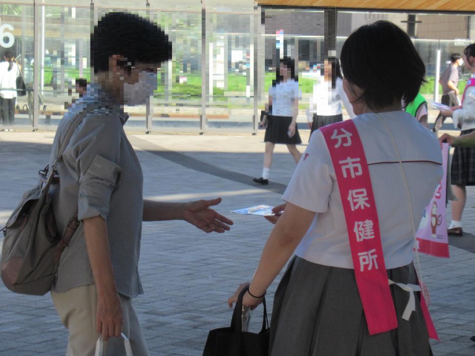 自殺予防週間街頭キャンペーン（大分駅前）で啓発物品を配布する高校生の写真