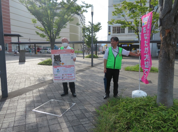 市職員が大分駅前で自殺予防週間ののぼり旗等を掲げている写真